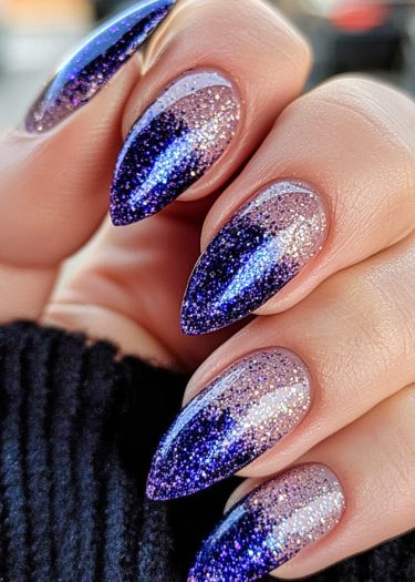 Elegant stiletto ombre nails with silver glitter and deep indigo blue tips shine beautifully.