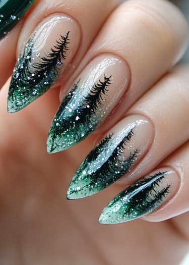 Elegant stiletto nails with green ombre and glittery evergreen tree designs for a natural look.