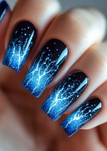 Stunning stormy night sky nails showcase electric blue lightning and a glossy gradient design.