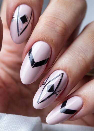 Elegant almond-shaped nails with pastel pink base and striking black geometric nail art design.