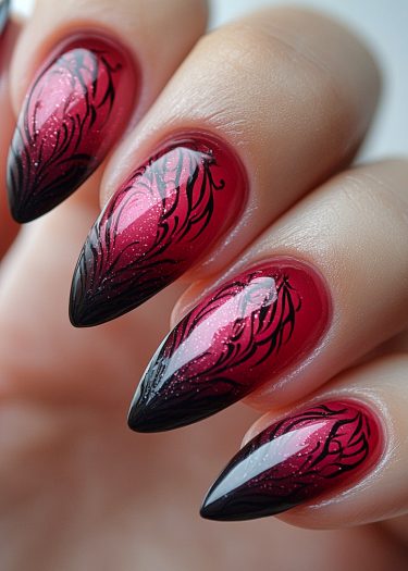 Elegant red and black ombre nails with intricate designs and shimmering glitter accents.