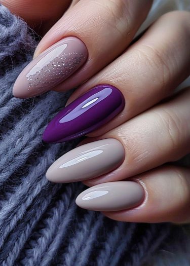 Elegant taupe and purple nail art with almond shapes and glitter accents.