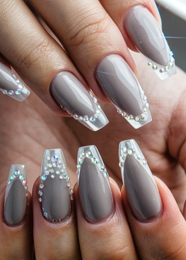 Elegant taupe coffin nails with rhinestone tips, showcasing sophisticated nail art and design.