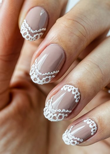 Elegant taupe nails featuring intricate white lace designs for a sophisticated manicure.