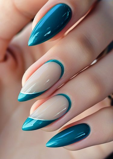 Elegant teal stiletto nail art with dual tones and precise designs for a creative look.