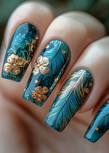 Luxurious teal nail art with golden floral and feather designs for elegant manicures.