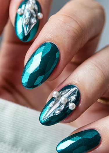 Elegant teal gemstone nail art with rhinestones and pearls for a sophisticated manicure.