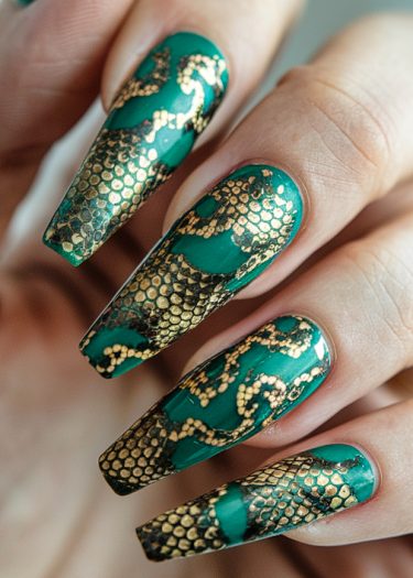 Luxurious green and gold nail art featuring intricate patterns on long, elegant fingernails.