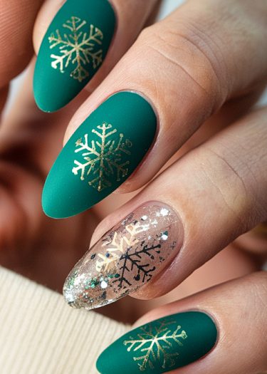 Elegant teal and gold winter snowflake nail art design on beautifully manicured hands.