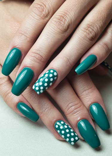 Elegant teal manicure with polka dots showcasing beautifully manicured almond-shaped nails.