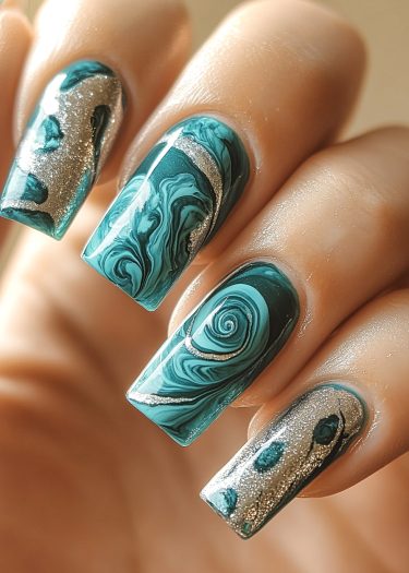 Elegant teal marble nail art with intricate designs and shimmering silver accents for a luxurious look.