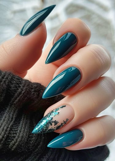 Elegant teal almond-shaped nails with intricate nail art and glittery design on ring finger.