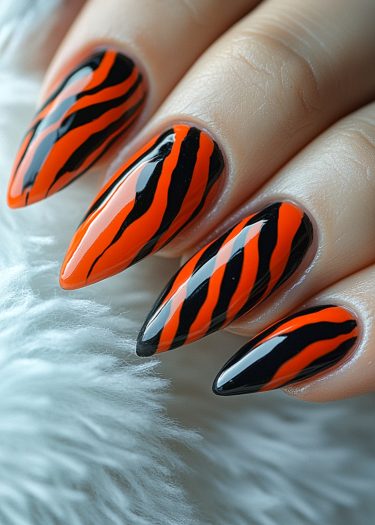 Vivid tiger stripe nail art in orange and black, showcasing bold and glossy design.