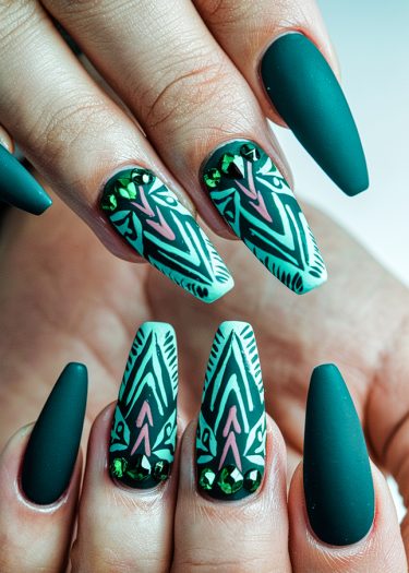 Intricate tribal designs on matte teal nails with gemstones for a bold, elegant look.