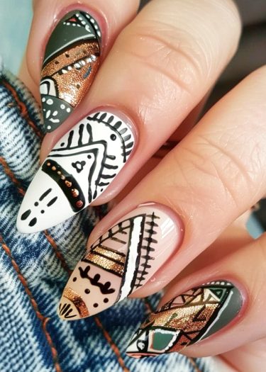 Intricately designed tribal nail art featuring earthy tones, geometric patterns, and metallic accents.