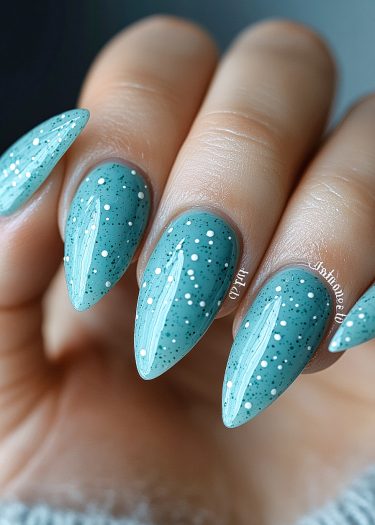 Elegant stiletto nails in soft teal with white polka dots and black speckles.