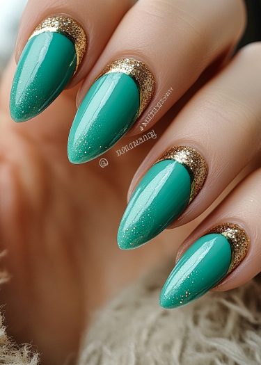 Teal almond-shaped nails with gold glitter create an elegant, eye-catching manicure design.