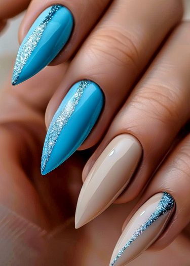 Elegant turquoise and beige stiletto nail art with silver glitter accents and glossy finish.