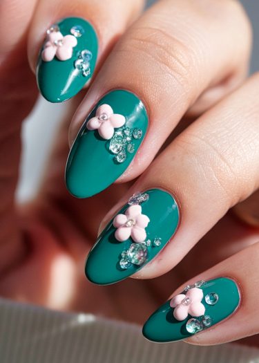 Elegant teal floral nail art with sparkling accents for a trendy, sophisticated look.