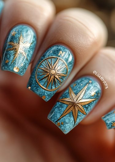 Elegant teal and gold nail art featuring compass and star designs for a nautical theme.