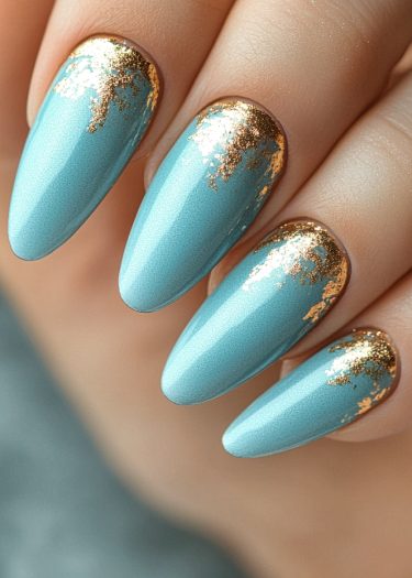 Elegant aqua blue and gold leaf nail art design, featuring almond-shaped manicured nails.