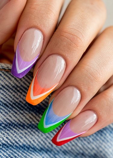 Vibrant almond-shaped manicure with gradient colors and angular stripes on manicured nails.