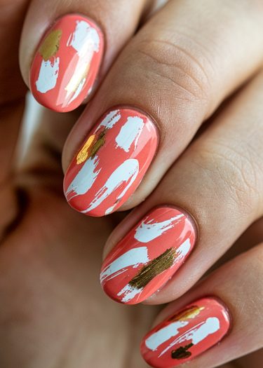 Vibrant coral almond-shaped nails with abstract white and gold nail art design.