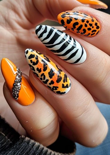 Vibrant nail art featuring leopard prints, zebra stripes, and glossy orange designs.