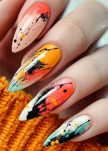 Artistic stiletto nail design with vibrant pastel colors, abstract splatters, and golden accents.