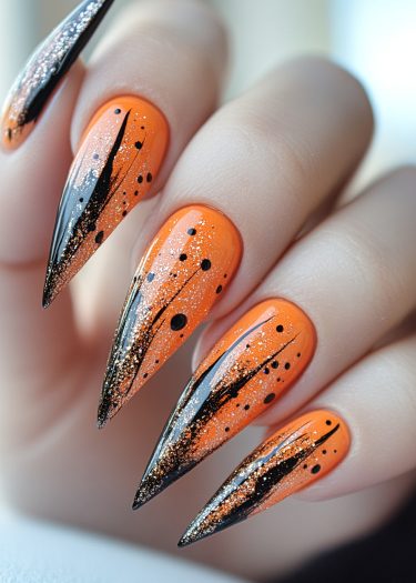 Stiletto nails in vibrant orange with black patterns and shimmering glitter for a bold look.