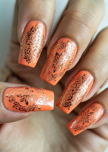 Vibrant orange and gold nail art featuring intricate designs and glossy finish on manicured nails.