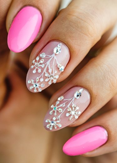 Bright pink and floral nail art with rhinestones for a stylish, elegant manicure.