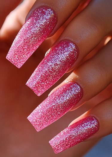 Glamorous coffin-shaped vibrant pink glitter nails shining in natural light with stunning elegance.