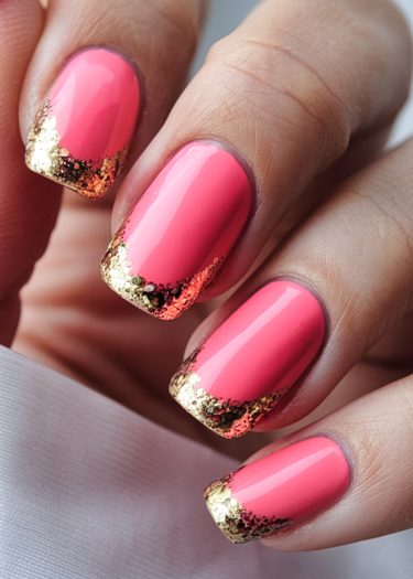 Vibrant pink nails with gold glitter tips showcase elegant manicure design and stunning detail.