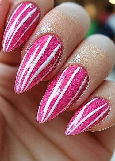 Elegant almond-shaped nails featuring vibrant pink polish and intricate white nail art designs.