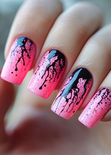 Bold pink gradient nail art with black splatter design for a chic, modern look.