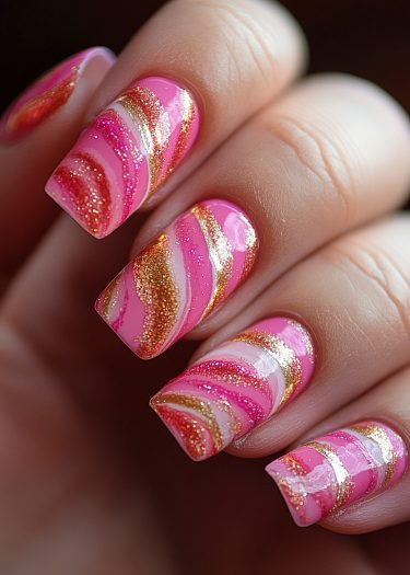 Gorgeous pink and gold nail art with glitter, showcasing intricate designs and a polished finish.