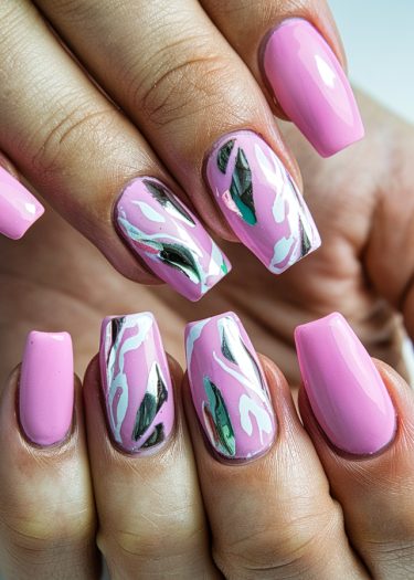 Stylish medium-length pink nails feature intricate designs and a glossy finish for a chic look.