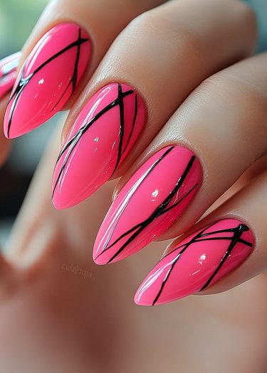 Intricately manicured vibrant pink stiletto nails with artistic black line designs.