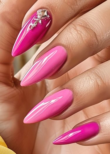 Vibrant fuchsia stiletto nails adorned with rhinestones, showcasing elegant, glossy manicure artistry.