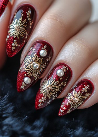 Glamorous red stiletto nails featuring gold floral designs and pearls for elegant nail art.