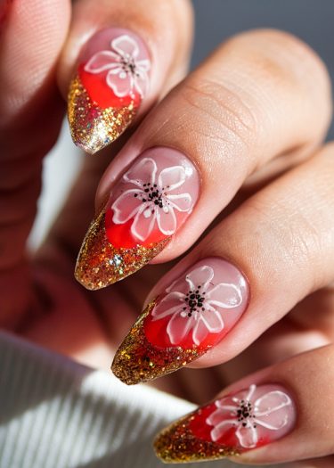 Vibrant red and gold nail art featuring exquisite hand-painted flowers and glittery tips.