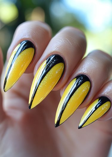 Vibrant yellow stiletto nails with black accents showcase stunning nail art design.