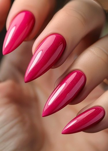 Vibrant magenta stiletto nails with a glossy finish, showcasing bold and stylish nail art.