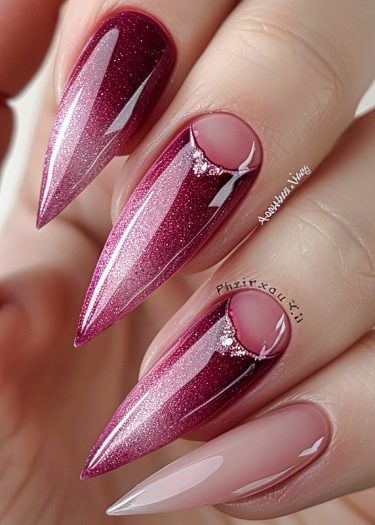 Luxurious wine-red glitter stiletto nails adorned with rhinestones for a glamorous manicure.