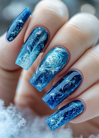 Elegant winter blue nail art with intricate white and silver designs, perfect for seasonal events.