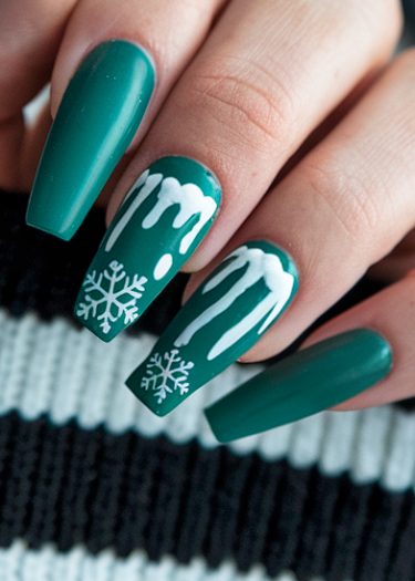 Elegant emerald green winter nail art with intricate snowflake designs and glossy finish.