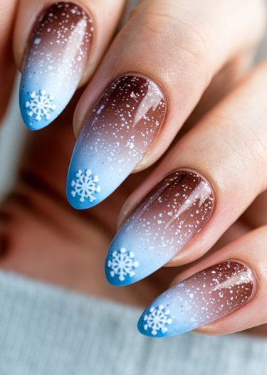 Chic winter ombre nail art with brown to blue gradient and intricate snowflake designs.