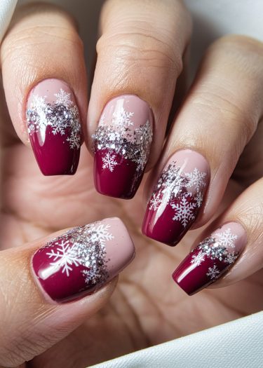 Elegant winter snowflake nail art with burgundy gradient and sparkling glitter accents.