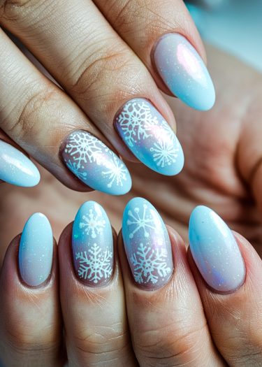 Icy blue winter snowflake nail art with shimmering finish for a festive look.